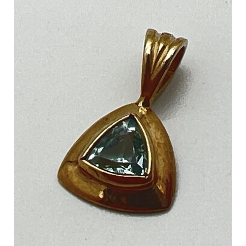 1145 - A modern design triangular shaped 9ct gold pendant set with a trilliant cut blue topaz.  Fixed bale ... 