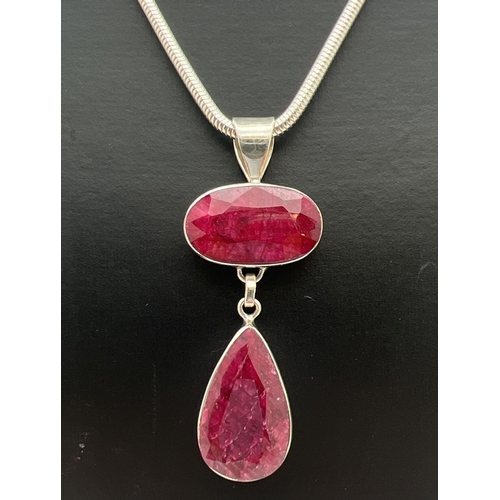 1148 - A modern design drop style silver pendant set with an oval cut and a teardrop cut ruby. On a 16 inch... 