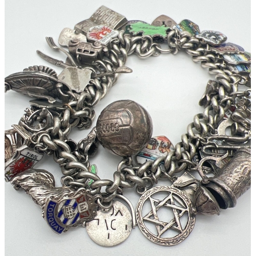 1153 - A vintage silver charm bracelet with padlock, safety chain and 43 silver & white metal charms. Charm... 