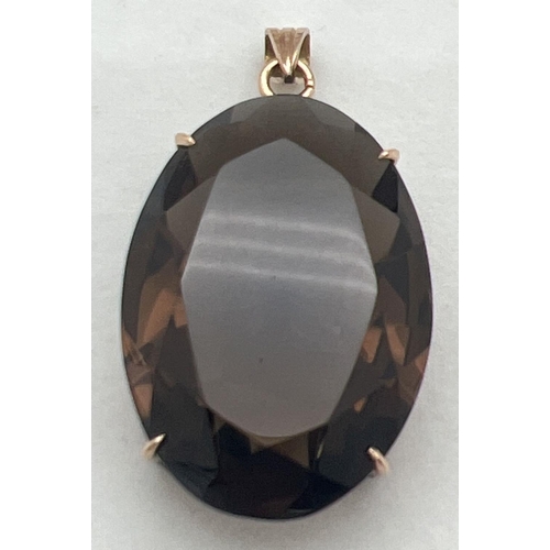 1154 - A  gold drop pendant set with a large oval cut smoked quartz stone. Indistinct gold marks to hanging... 