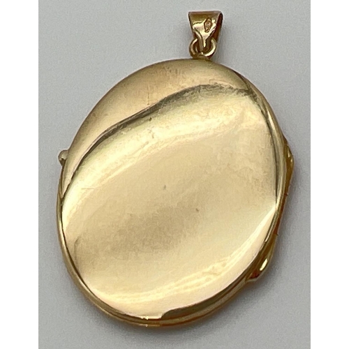 1155 - A vintage 9ct gold large oval locket with floral engraving to front. Glass panels to interior. Gold ... 