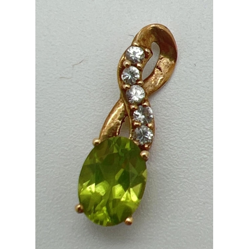 1166 - A 9ct gold pendant with twist design bale set with an oval cut peridot and 5 small round cut white s... 