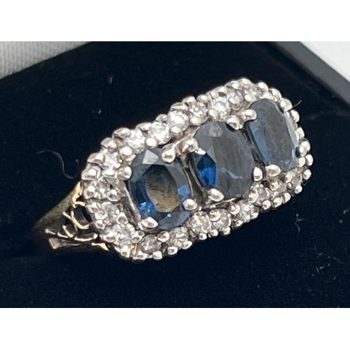 1177 - A 18ct gold sapphire and diamond trilogy dress ring. 3 central oval cut sapphires surrounded by 22 s... 