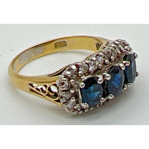 1177 - A 18ct gold sapphire and diamond trilogy dress ring. 3 central oval cut sapphires surrounded by 22 s... 