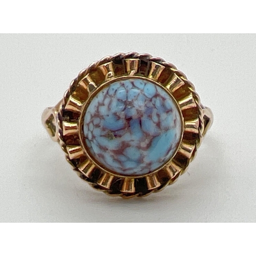 1194 - A vintage 18ct gold dress ring set with a round cabochon of blue and maroon speckled glass. Frilled ... 