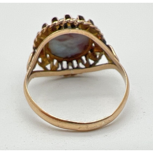 1194 - A vintage 18ct gold dress ring set with a round cabochon of blue and maroon speckled glass. Frilled ... 