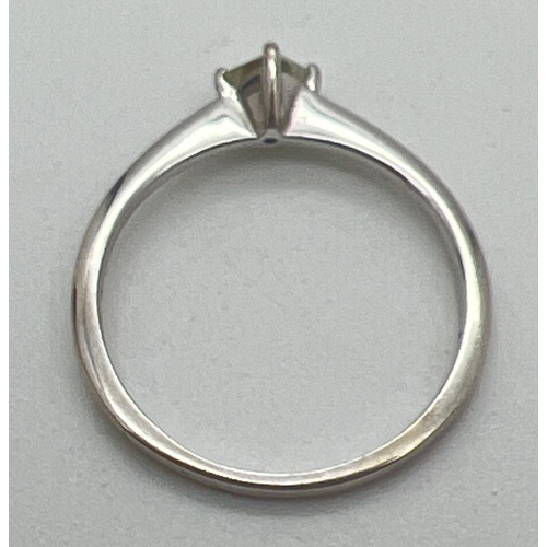 1176 - A 18ct white gold diamond solitaire ring. Plain band set with a 0.10ct square cut diamond. Gold mark... 