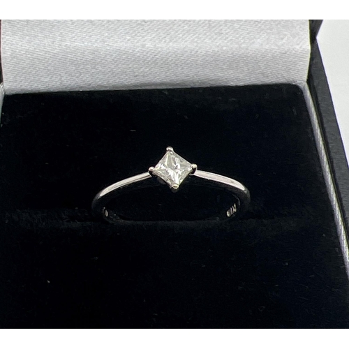 1176 - A 18ct white gold diamond solitaire ring. Plain band set with a 0.10ct square cut diamond. Gold mark... 