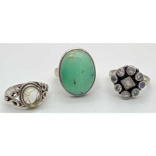 1178 - 3 silver stone set dress rings to include a flower design ring set with moonstones. Silver marks to ... 