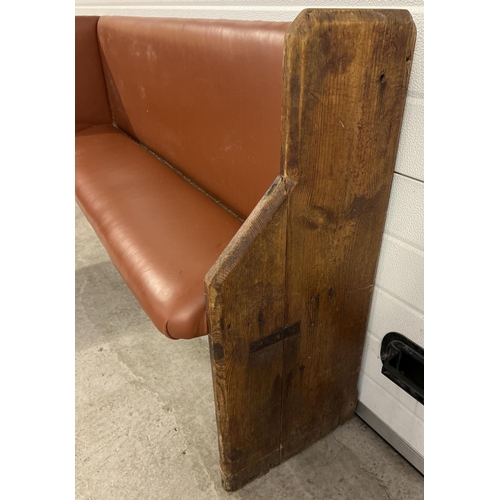 1391 - A corner bench seat as taken from a local pub, originally made from antique pews. Covered in tan col... 