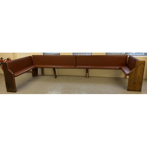 1393 - A large corner bench seat as taken from a local pub, originally made from antique pews. Covered in t... 