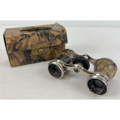 1290 - A pair of vintage soft marbled effect, leather cased and bound opera glasses. Red velvet lined inter... 