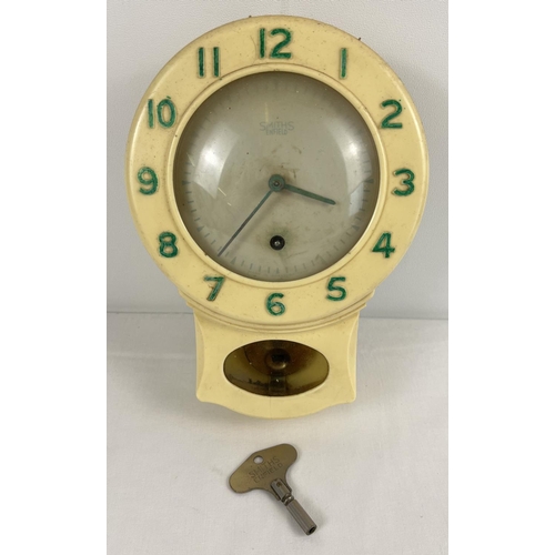 1265 - A 1940/50's cream bakelite cased Smiths Enfield kitchen clock with pendulum. Green numerals ( re-pai... 