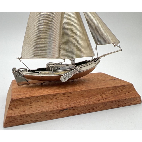 1217 - A vintage silver model of a sailing boat mounted on a wooden plinth. Very well detailed with matte f... 