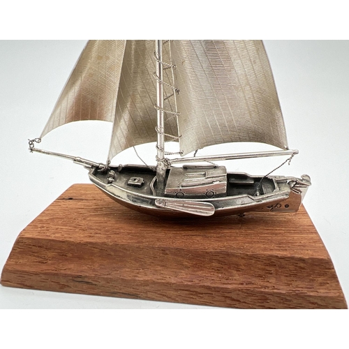 1217 - A vintage silver model of a sailing boat mounted on a wooden plinth. Very well detailed with matte f... 