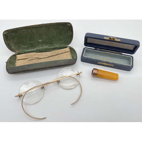 1219 - An Edwardian gold rimmed amber cheroot holder together with a pair spectacles with 12ct gold arms an... 