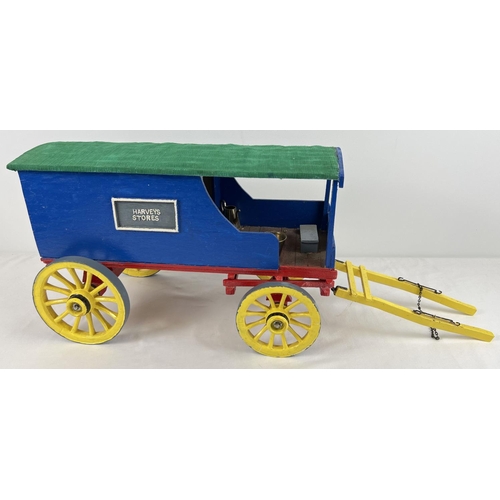 1357 - A painted wooden model caravan of Harveys Stores with green fabric roof. Together with metal accesso... 