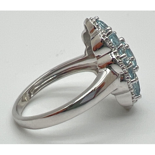 1180 - A 925 silver and blue topaz statement cocktail ring, size P. Central oval cut blue topaz surrounded ... 