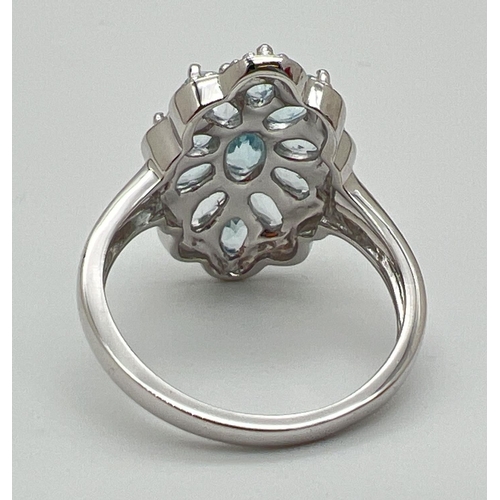 1180 - A 925 silver and blue topaz statement cocktail ring, size P. Central oval cut blue topaz surrounded ... 