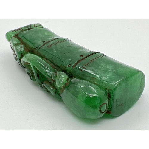 1292 - A carved piece of jade in the form of bamboo with foliate detail. Approx. 6.5cm long.