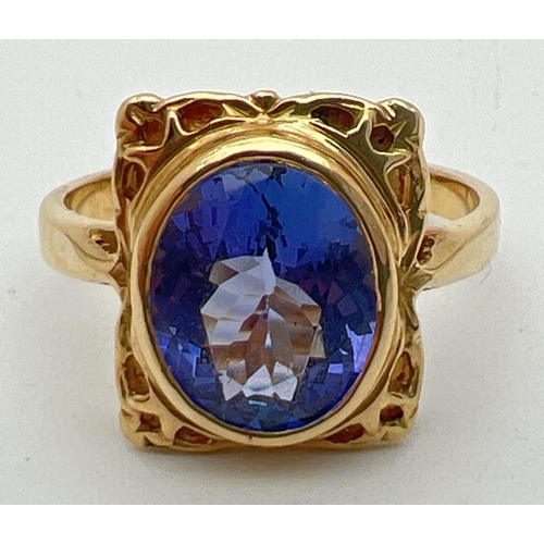 1 - An 18ct yellow gold and tanzanite ring with a decorative square shaped mount. Large oval cut tanzani... 