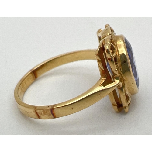 1 - An 18ct yellow gold and tanzanite ring with a decorative square shaped mount. Large oval cut tanzani... 