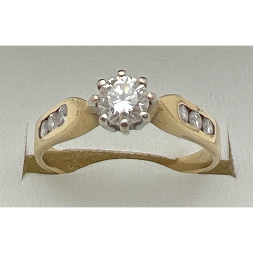 5 - An 18ct gold .33ct diamond solitaire ring with diamond channel set shoulders. Fully hallmarked insid... 