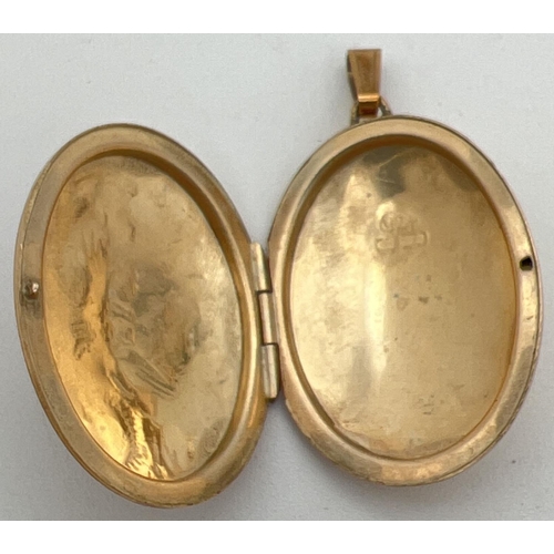 8 - A 9ct gold oval shaped locket with engraved scroll & foliate design to front. Fully hallmarked to re... 