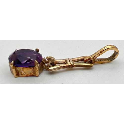 12 - A 9ct gold and amethyst love and kisses design pendant with oval cut stone (approx. 9mm x 7mm). Appr... 