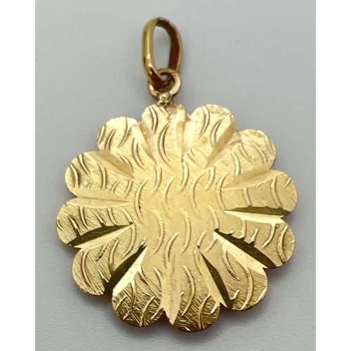 19 - An 18ct yellow gold flower shaped pendant featuring Nefertiti. Bale stamped 750 and pendant tests as... 