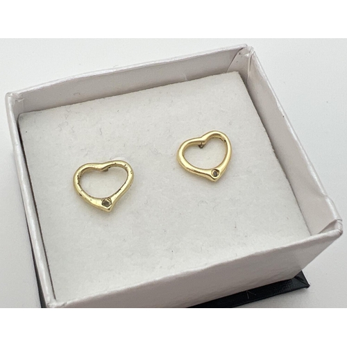 20 - A pair of silver gilt open heart shaped stud earrings, each set with a small diamond. Reverse of stu... 