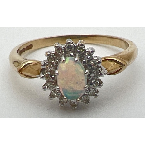 21 - A 9ct gold, opal and diamond dress ring with decorative shoulder detail. Central oval opal cabochon ... 