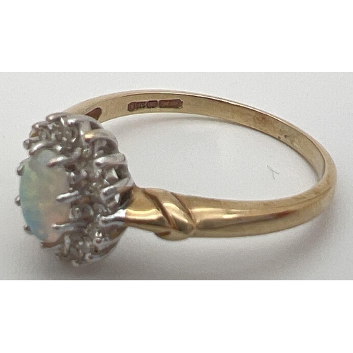 21 - A 9ct gold, opal and diamond dress ring with decorative shoulder detail. Central oval opal cabochon ... 