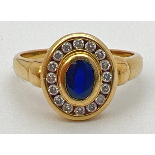 24 - An 18ct gold, sapphire and diamond ring with central oval shaped bezel set sapphire (approx. 6mm x 4... 