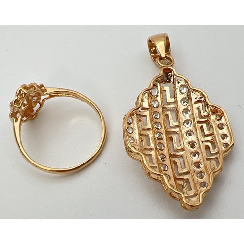 31 - A 21ct gold plated pendant and matching ring set with clear stones. Both with pierced work Greek key... 