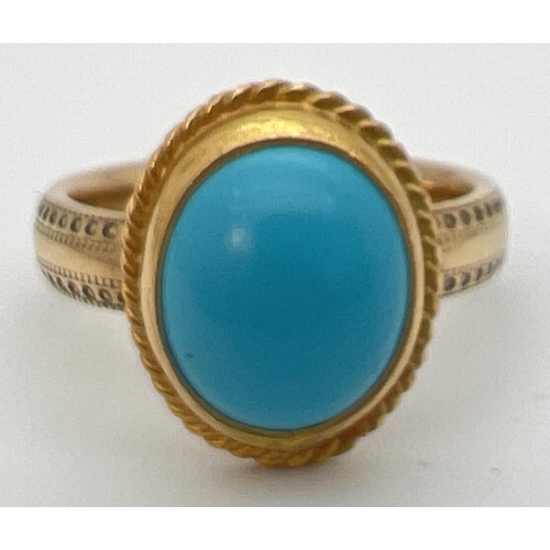 34 - A 9ct gold dress ring set with an oval cabochon of turquoise. Band of ring has studded engraved deta... 