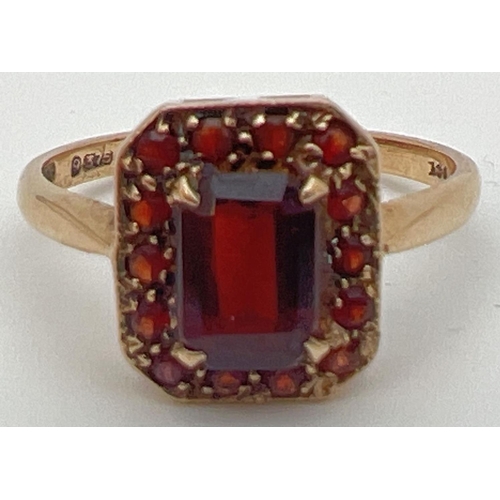 38 - A 9ct gold and garnet dress ring with central emerald cut stone in a basket style setting. Surrounde... 