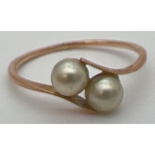 47 - A vintage 9ct gold ring with 2 tension set pearls in a twist design setting. Stamped 9ct to outside ... 