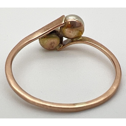 47 - A vintage 9ct gold ring with 2 tension set pearls in a twist design setting. Stamped 9ct to outside ... 