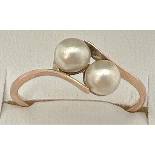 47 - A vintage 9ct gold ring with 2 tension set pearls in a twist design setting. Stamped 9ct to outside ... 