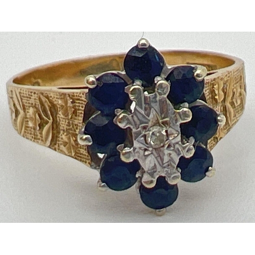 51 - A vintage 9ct gold, sapphire and diamond ring with textured shoulders with floral design. Central il... 