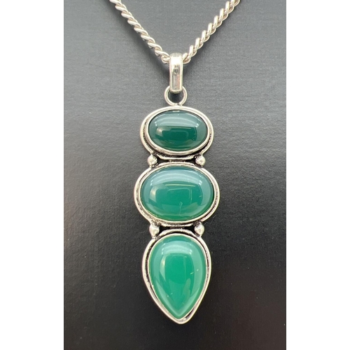 55 - A large green 3 stone pendant in a white metal mount, on an 18