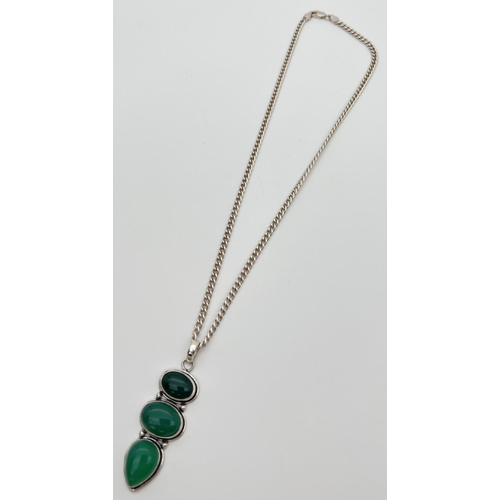 55 - A large green 3 stone pendant in a white metal mount, on an 18