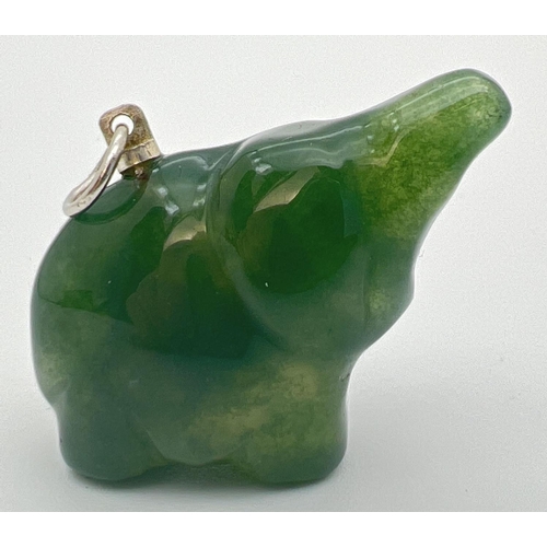 63 - A carved jade pendant in the form of an elephant, with white metal hanging bale. Approx. 2.5cm x 3cm... 