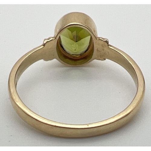 64 - A modern 9ct gold ring with an oval bezel set peridot and ridged design to shoulders. Fully hallmark... 