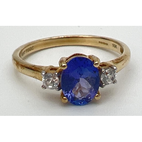 76 - A 10k yellow gold dress ring set with central oval tanzanite between 2 round cut white spinels. Full... 