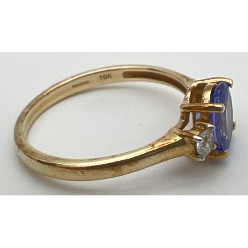 76 - A 10k yellow gold dress ring set with central oval tanzanite between 2 round cut white spinels. Full... 