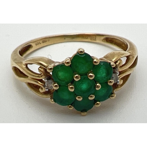 83 - A 9ct gold & emerald cluster ring set with 2 small diamonds on decorative pierced work shoulders. A ... 