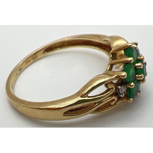 83 - A 9ct gold & emerald cluster ring set with 2 small diamonds on decorative pierced work shoulders. A ... 