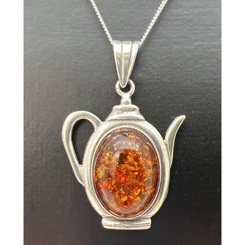 90 - A silver and amber pendant in the shape of a teapot, on a 16